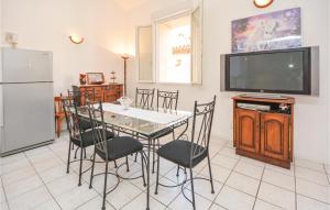 een eetkamer met een tafel en stoelen en een televisie bij 2 Bedroom Pet Friendly Home In Cessenon Sur Orb in Cessenon