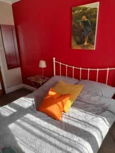 a bedroom with a bed with a red wall at Bastwick House B&B in Great Yarmouth
