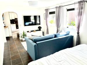 a living room with a blue couch and a bed at Casa Tureholm - ett mysigt hus i idylliska Trosa in Trosa