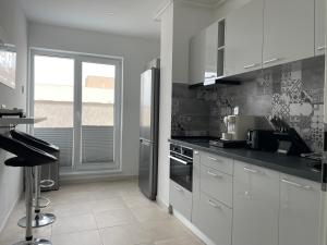 a kitchen with white cabinets and a refrigerator at Lakeview 2 Room Penthouse Rooftop Terrace W15 in Bucharest