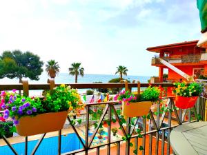 een balkon met bloeiende planten en een zwembad bij Taormina by the sea in Mazzeo