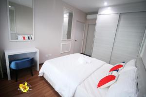 een slaapkamer met een wit bed met rode kussens bij I-City Homestay@5 min walk to shopping Mall in Shah Alam