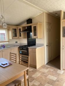 a kitchen with a table and a dining room at Skegness B10 in Chapel Saint Leonards
