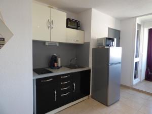 uma cozinha com um frigorífico e um micro-ondas em Appartement T2 coquet, proche mer, Narbonne Plage em Narbonne Plage