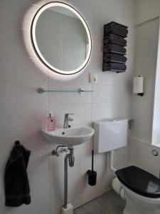 uma casa de banho com um lavatório, um WC e um espelho. em Marianna - studio for two em Groningen