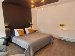 a bedroom with a large bed with orange pillows at Marianna - studio for two in Groningen