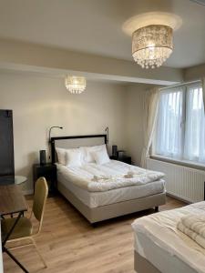 a bedroom with a large bed and a chandelier at Zajazd Arkadia in Siemiatycze