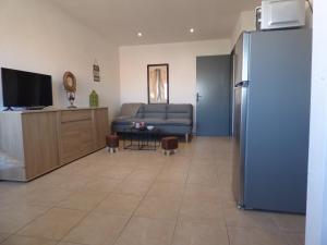 uma sala de estar com um frigorífico e um sofá em Appartement T2 coquet, proche mer, Narbonne Plage em Narbonne Plage