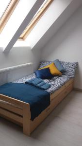 een slaapkamer met een bed met blauwe en gele kussens bij Bursztynowe Wczasy Sasino in Sasino