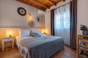 a bedroom with a bed with a blue blanket and a window at Bed And Breakfast Mirador Infinito in Alhaurín el Grande