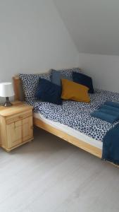 a bed with blue and yellow pillows in a room at Bursztynowe Wczasy Sasino in Sasino