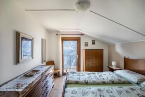 a bedroom with a bed and a large window at La Mansarda di Chiara e Silvio in Trasquera