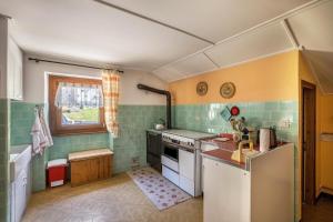 a small kitchen with green and yellow tiles at La Mansarda di Chiara e Silvio in Trasquera
