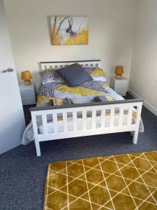 ein Schlafzimmer mit einem weißen Bett und zwei Nachttischen in der Unterkunft Town house in ideal location central Enniskillen in Enniskillen