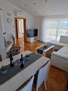 een woonkamer met een tafel met wijnflessen erop bij ZARA BEAUTY in Kožino