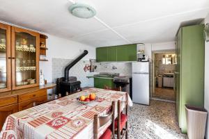 - une cuisine avec des placards verts et une table avec des fruits dans l'établissement Casa Comero, à Trasquera