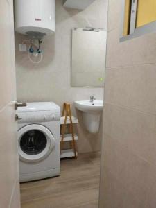 un bagno con lavatrice e lavandino di KubiK APARTAMENTOS K3 a Cáceres