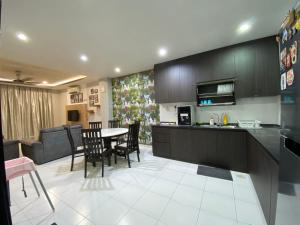 eine Küche und ein Wohnzimmer mit einem Tisch und Stühlen in der Unterkunft D' Niice Garden 2 Bukit Indah 7 Mins Legoland in Johor Bahru
