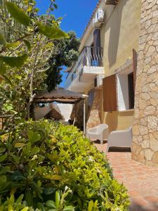 a patio with an umbrella and chairs next to a building at Villa Sofia in Lampedusa
