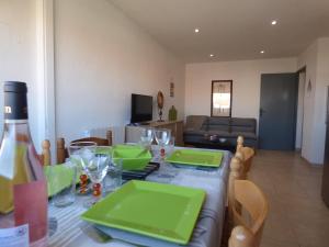 uma mesa com placas verdes numa sala de estar em Appartement T2 coquet, proche mer, Narbonne Plage em Narbonne Plage