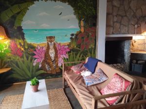 a living room with a mural of a cheetah at Punto Verde Ecological house in Montañita