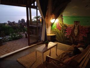una sala de estar con una mesa y una pared con un mural en Punto Verde Ecological house, en Montañita