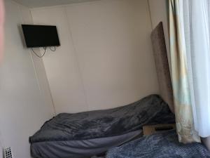 a small room with a bed and a tv at 2BR-Sleeps6-Fireplace-Parking-Patio-Seaside in Clacton-on-Sea