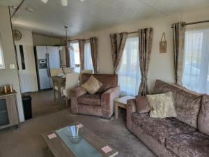 a living room with a couch and chairs and a table at 2BR-Sleeps6-Fireplace-Parking-Patio-Seaside in Clacton-on-Sea
