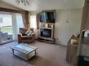 a living room with a couch and a tv at 2BR-Sleeps6-Fireplace-Parking-Patio-Seaside in Clacton-on-Sea
