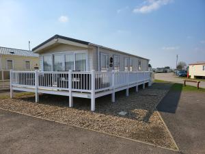 a small house with a white porch and a porch at 2BR-Sleeps6-Fireplace-Parking-Patio-Seaside in Clacton-on-Sea