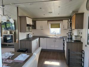 a kitchen with a table and a sink and a counter at 2BR-Sleeps6-Fireplace-Parking-Patio-Seaside in Clacton-on-Sea