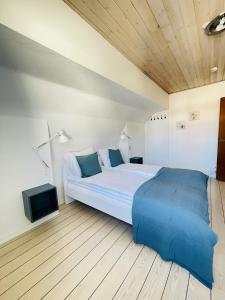 a bedroom with a large bed with blue pillows at aday - Frederikshavn City Center - Room 5 in Frederikshavn
