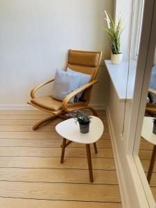 a rocking chair and a table in a room at aday - Frederikshavn City Center - Room 5 in Frederikshavn