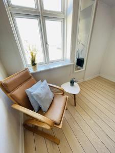 uma cadeira num quarto com um espelho e uma mesa em aday - Frederikshavn City Center - Room 5 em Frederikshavn