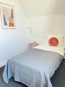 Schlafzimmer mit einem großen Bett und einem roten Kissen in der Unterkunft aday - Frederikshavn City Center - Single room in Frederikshavn