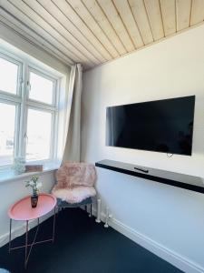 a living room with a large flat screen tv on the wall at aday - Frederikshavn City Center - Single room in Frederikshavn