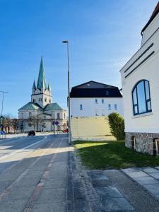 eine Kirche mit einem Kirchturm in der Mitte einer Straße in der Unterkunft aday - Frederikshavn City Center - Single room in Frederikshavn