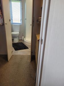 a bathroom with a toilet and a window and a door at Remarkable 3-Bed House in Hull in Hull