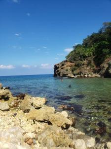 a group of people in the water on a rocky beach at Remarkable 2-Bed Villa in Fair Prospect Sea View in Port Antonio