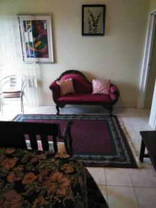 a living room with a red couch and a rug at Remarkable 2-Bed Villa in Fair Prospect Sea View in Port Antonio