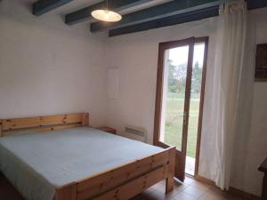 a bedroom with a bed and a large window at LE PETIT FROUAS NORD in Vielle-Saint-Girons