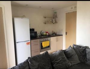 a kitchen with a couch and a white refrigerator at Immaculate 1-Bed Apartment in Stoke-on-Trent in Stoke on Trent