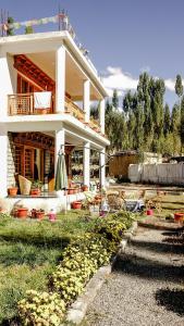 a house with a lot of flowers in front of it at Ladakh Eco House in Leh