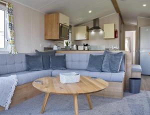 a living room with a blue couch and a table at Brand New 2 Bedroom Lodge Perfect for Families in Morecambe