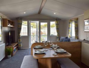 a living room with a wooden table with wine glasses at Brand New 2 Bedroom Lodge Perfect for Families in Morecambe