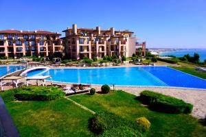 a large swimming pool in front of a large building at Ваканционни Апартаменти Калиакрия - Holiday Apartments Kaliakria in Topola