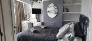 1 dormitorio con cama y espejo en Cosy and stylish house on the coast near Liverpool, en Wirral