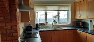 uma cozinha com um lavatório e uma janela em Cosy and stylish house on the coast near Liverpool em Wirral
