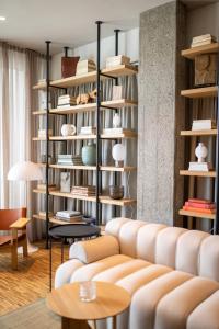 a living room with a couch and bookshelves at Hotel Heiden - Wellness am Bodensee in Heiden