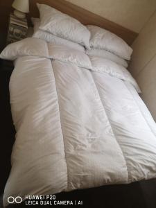 an unmade bed with white sheets and pillows at Lovely 2-Bed caravan in Walton on the Naze in Walton-on-the-Naze